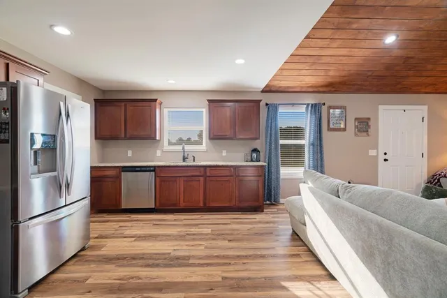 a kitchen with stainless steel appliances granite countertop a refrigerator and a sink