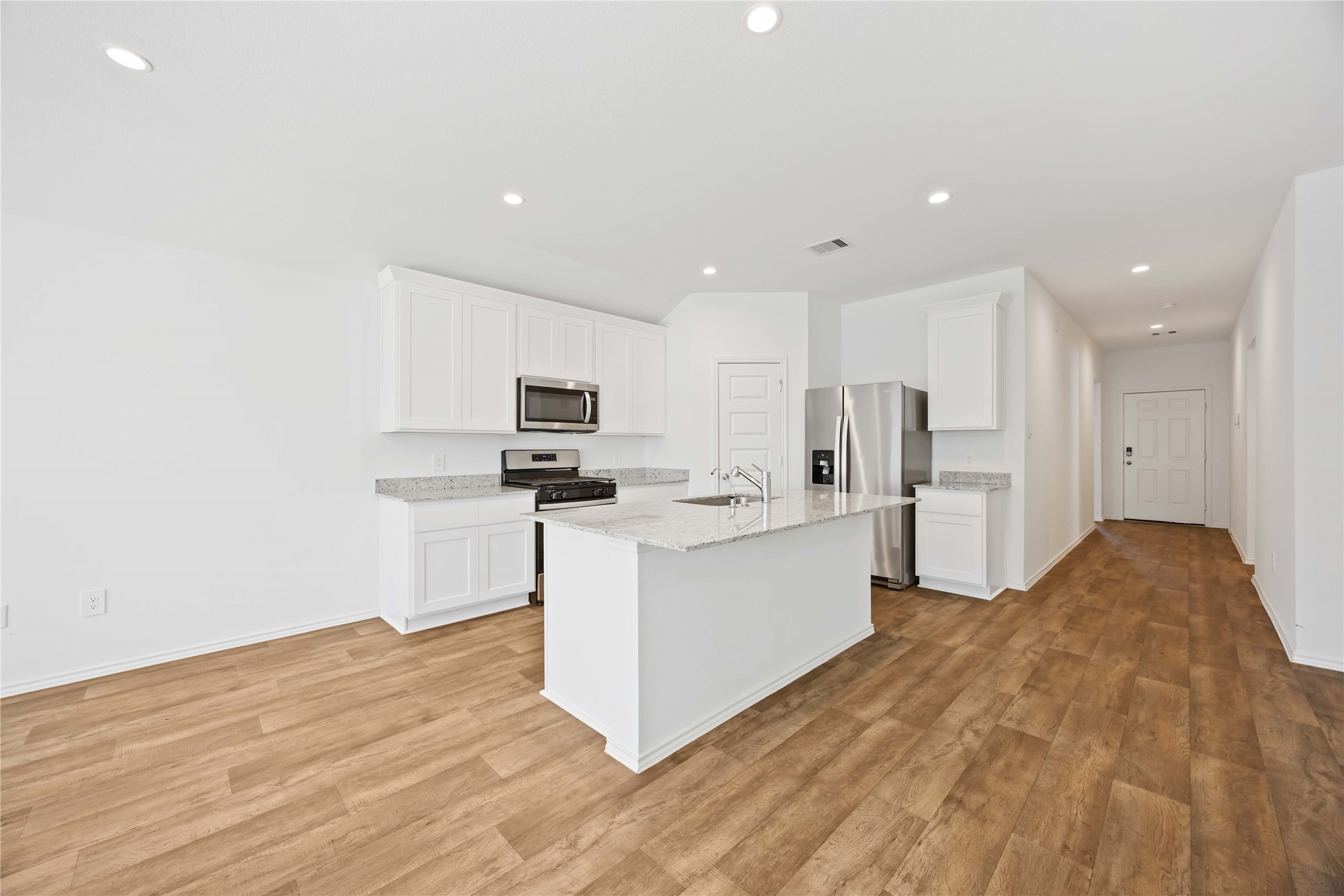 3719 Lanercost Lane Fulshear, TX 77441 - Photo 11 of 43 a kitchen with white cabinets and stainless steel appliances