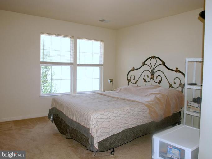 46182 Chester Terrace Sterling, VA 20165 - Photo 16 of 25 a bedroom with a bed and a window