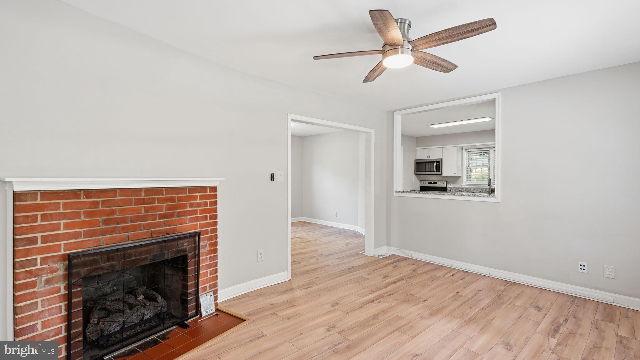 6499 Briggs Road Warrenton, VA 20187 - Photo 13 of 29 a view of a livingroom with a fireplace a ceiling fan and wooden floor