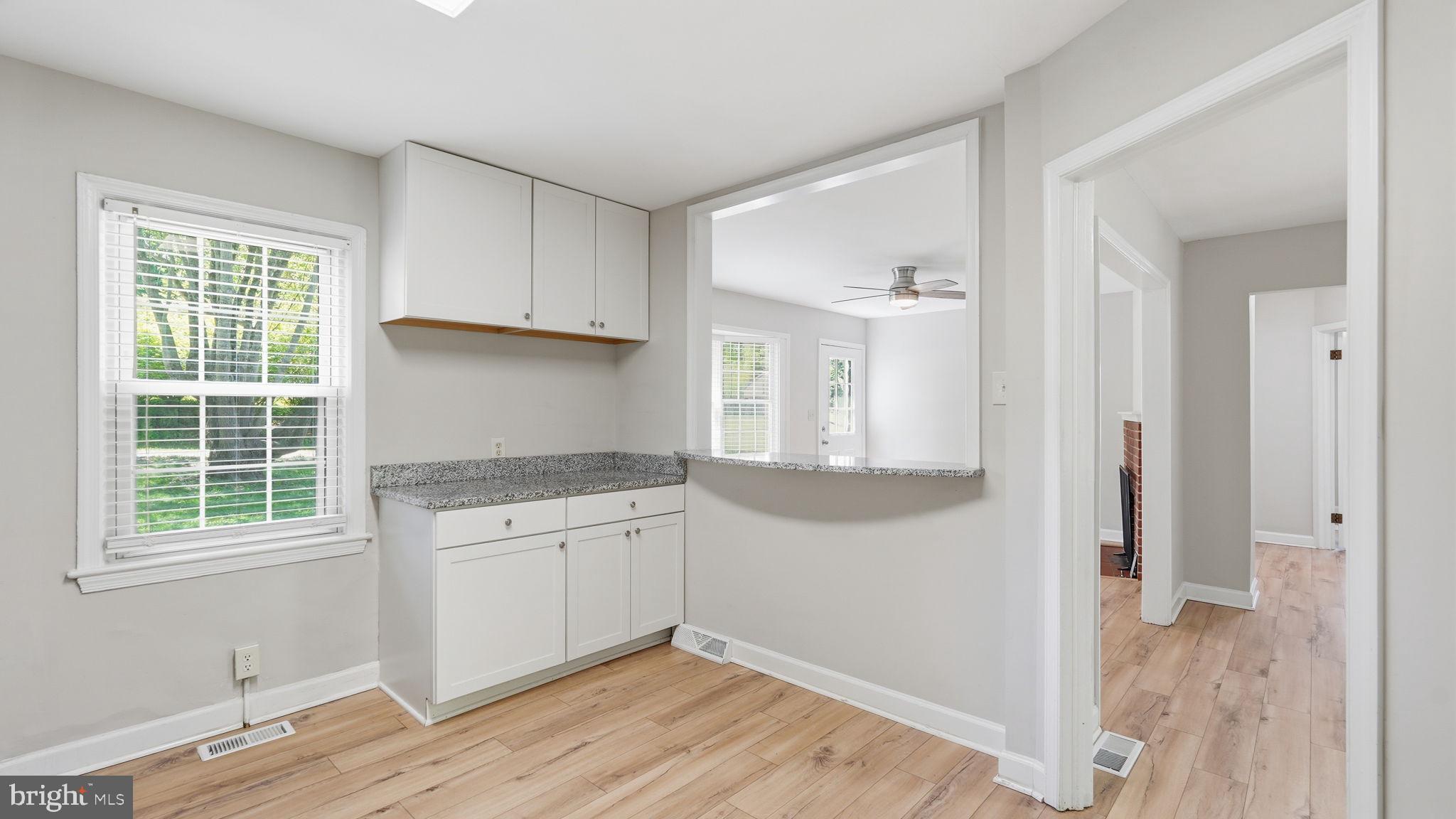 6499 Briggs Road Warrenton, VA 20187 - Photo 10 of 29 a kitchen with granite countertop a stove a sink and a refrigerator with wooden floor