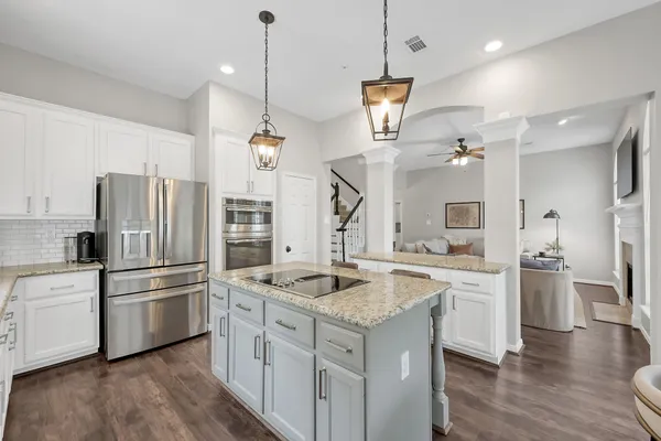 a kitchen with a refrigerator a sink and wooden floor