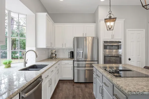 a kitchen with stainless steel appliances granite countertop a sink stove and refrigerator