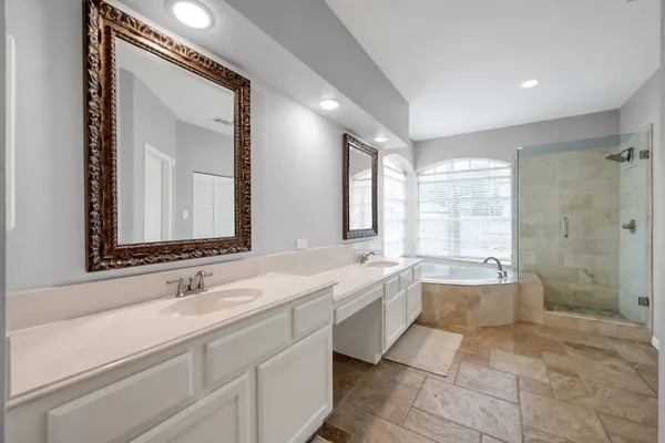 a bathroom with a double vanity sink mirror double and bathtub
