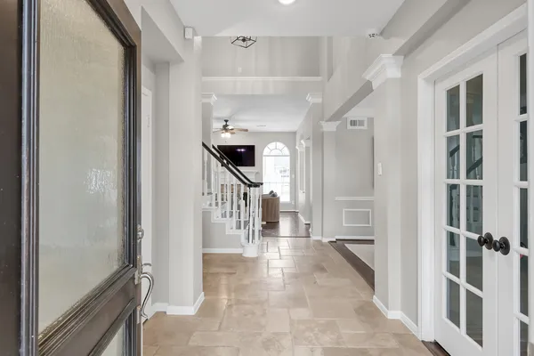 a hallway with a large window and a view of living room