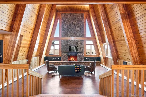 a living room with furniture a fireplace and wooden floor