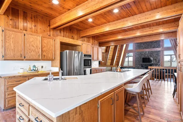 a kitchen with stainless steel appliances granite countertop a sink a stove and refrigerator