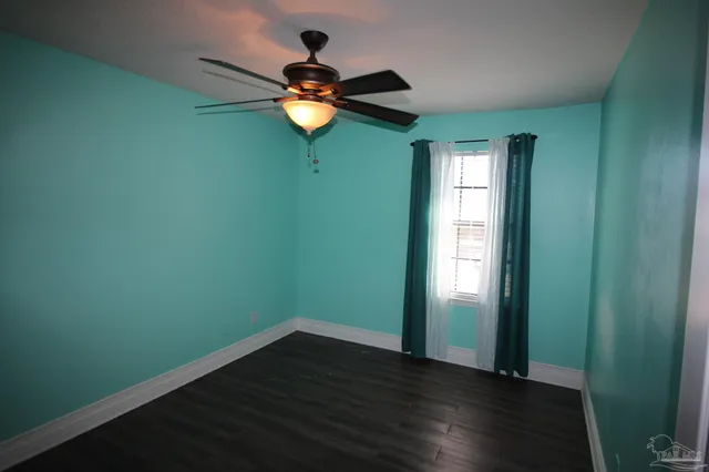 a view of a room with wooden floor and a window