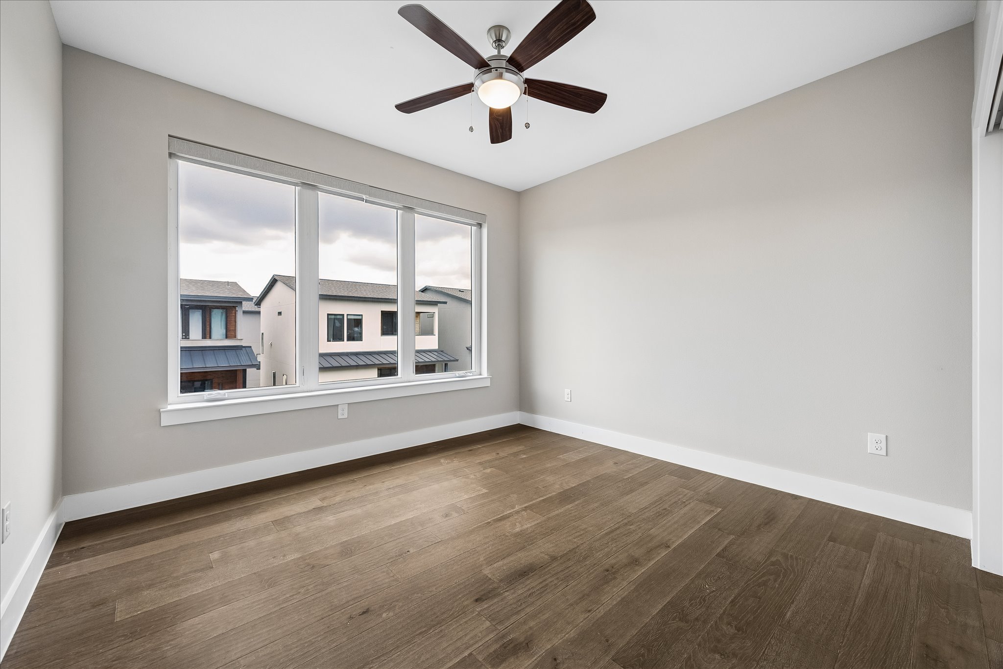 5006 Pecan Springs Road, Unit 6 Austin, TX 78723 - Photo 21 of 30 A well-lit room showcasing rich hardwood flooring and a functional ceiling fan for optimal comfort.
