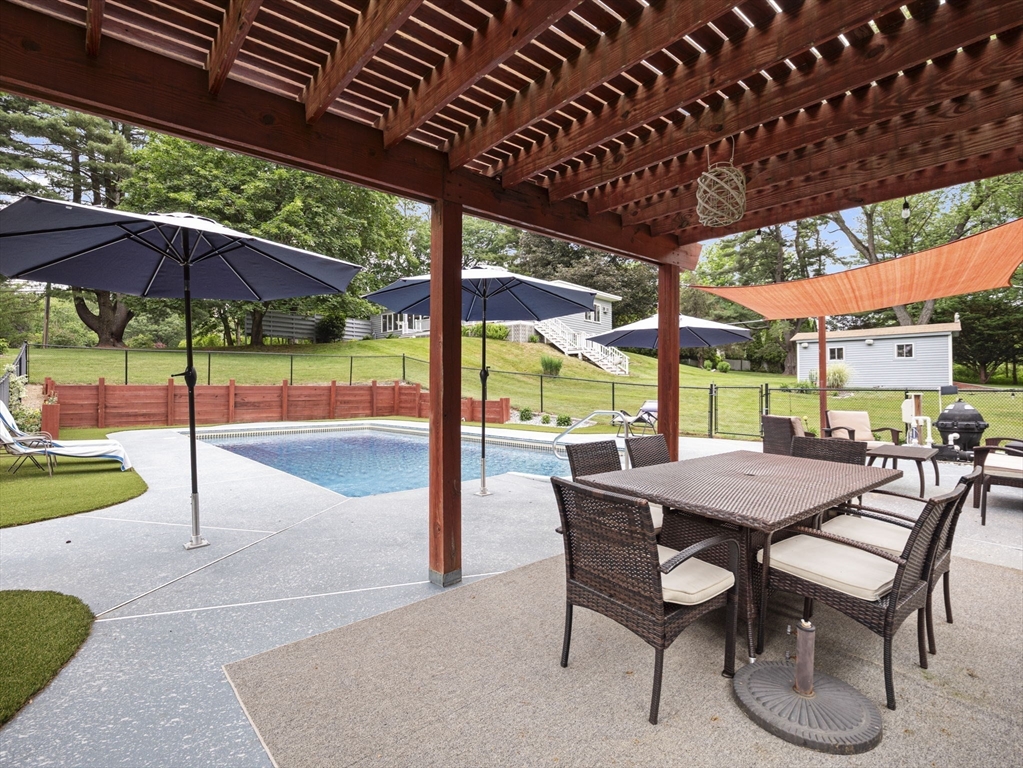 44 Locust Street Merrimac, MA 01860 - Photo 34 of 42 a view of a patio with a table and chairs under an umbrella with a barbeque grill and a table