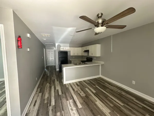 a kitchen with a refrigerator and white cabinets
