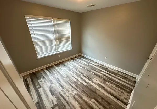 a view of wooden floor and windows in a room