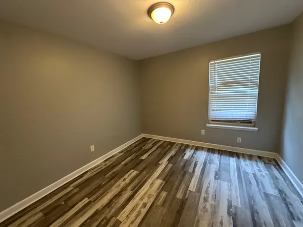 a view of a room with wooden floor and a window