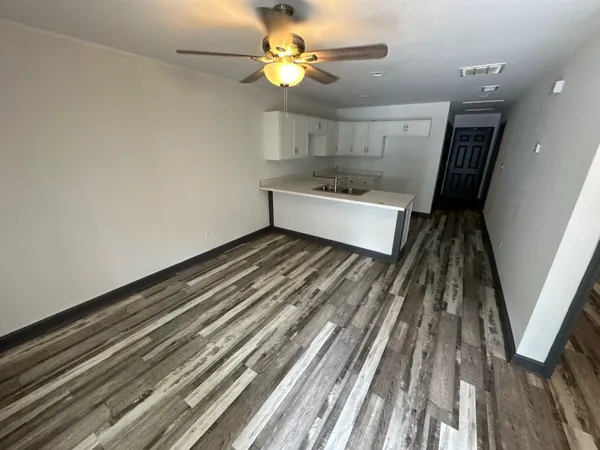 a kitchen view with wooden floor sink stove and refrigerator