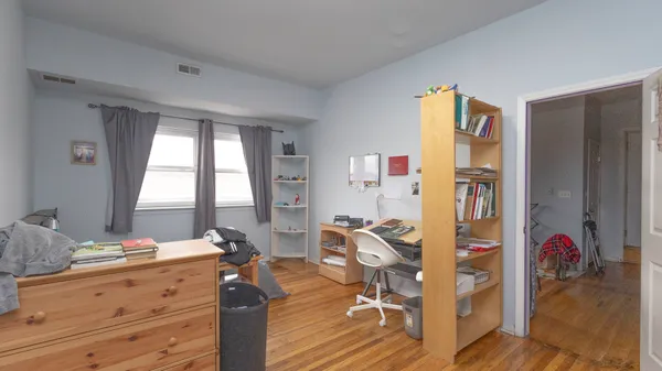 a bedroom with a bed and wooden floor