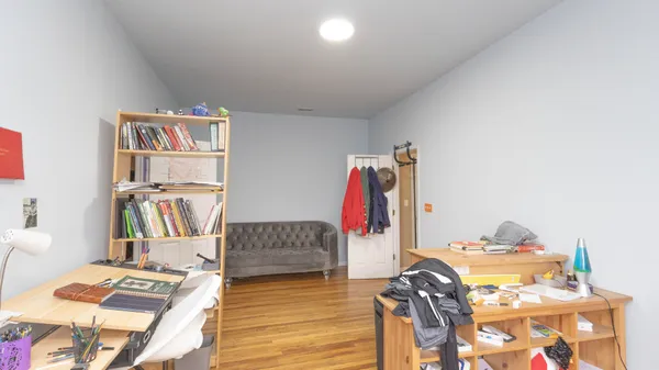a view of a workspace with furniture and wooden floor