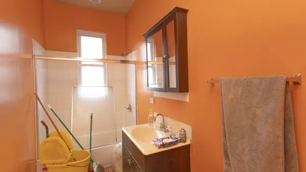 a bathroom with a sink and mirror with bathtub