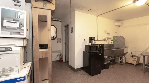 a view of a workspace with furniture and refrigerator