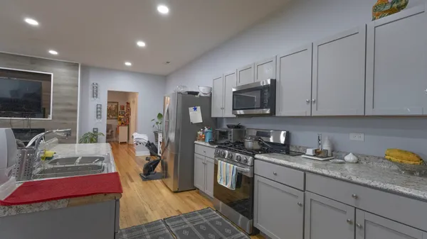 a kitchen with stainless steel appliances granite countertop a stove top oven a sink dishwasher a refrigerator and a microwave