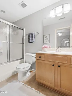 a bathroom with a sink vanity mirror and toilet