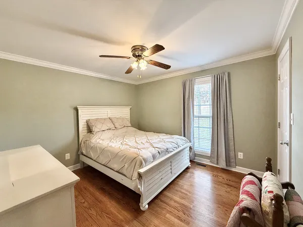a bedroom with a bed and wooden floor