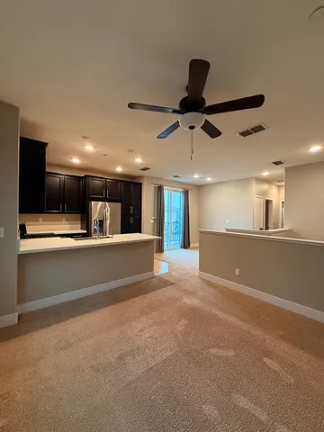 a kitchen with stainless steel appliances kitchen island granite countertop a refrigerator a sink a stove a microwave and island