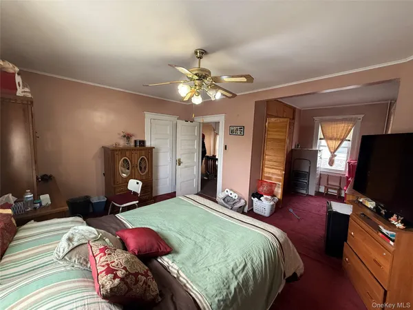 a bedroom with a bed gym equipment and a chandelier
