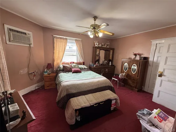 a bedroom with a bed dresser and a window