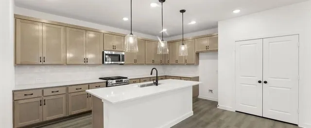 a kitchen with a sink stainless steel appliances and cabinets