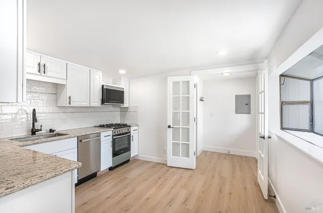 a kitchen with granite countertop a sink stove and refrigerator