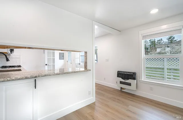 a kitchen with granite countertop a stove a sink and a refrigerator with wooden floor