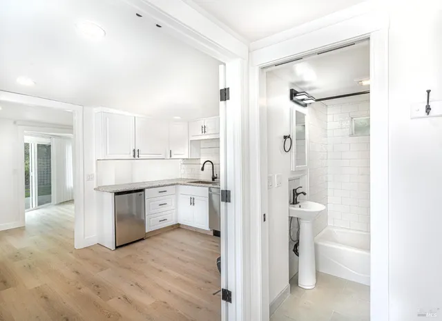 a bathroom with a granite countertop sink mirror and toilet