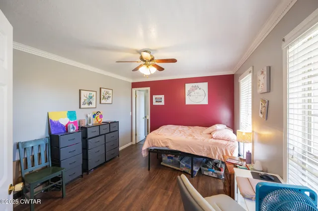 a bed room with a bed window and a chandelier