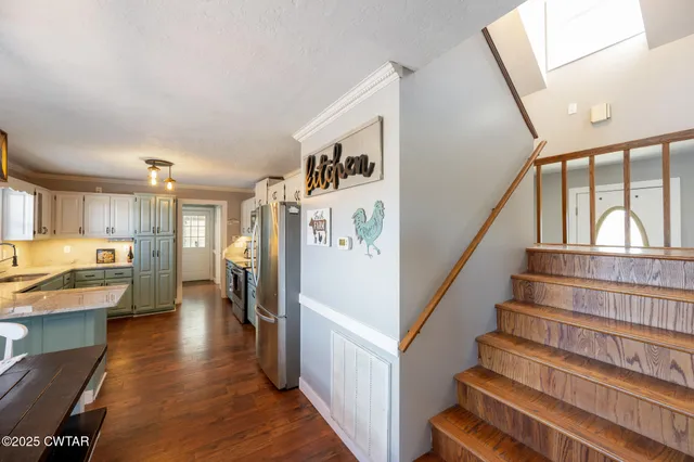 a view of staircase and living room with wooden floor