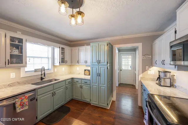 a kitchen with a sink appliances and cabinets
