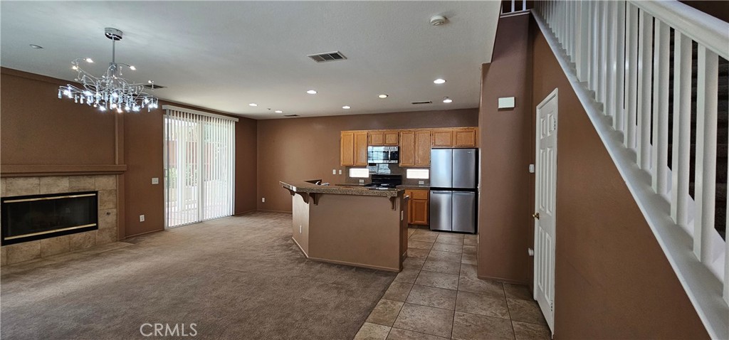 11305 Riverleaf Drive Riverside, CA 92505 - Photo 21 of 22 a kitchen with kitchen island granite countertop a refrigerator and a stove top oven