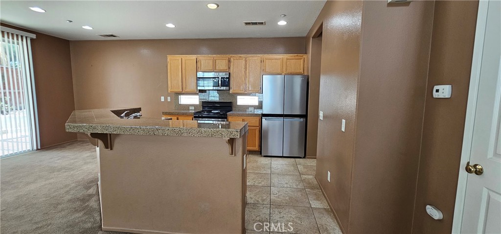 11305 Riverleaf Drive Riverside, CA 92505 - Photo 22 of 22 a kitchen with stainless steel appliances a refrigerator and a stove
