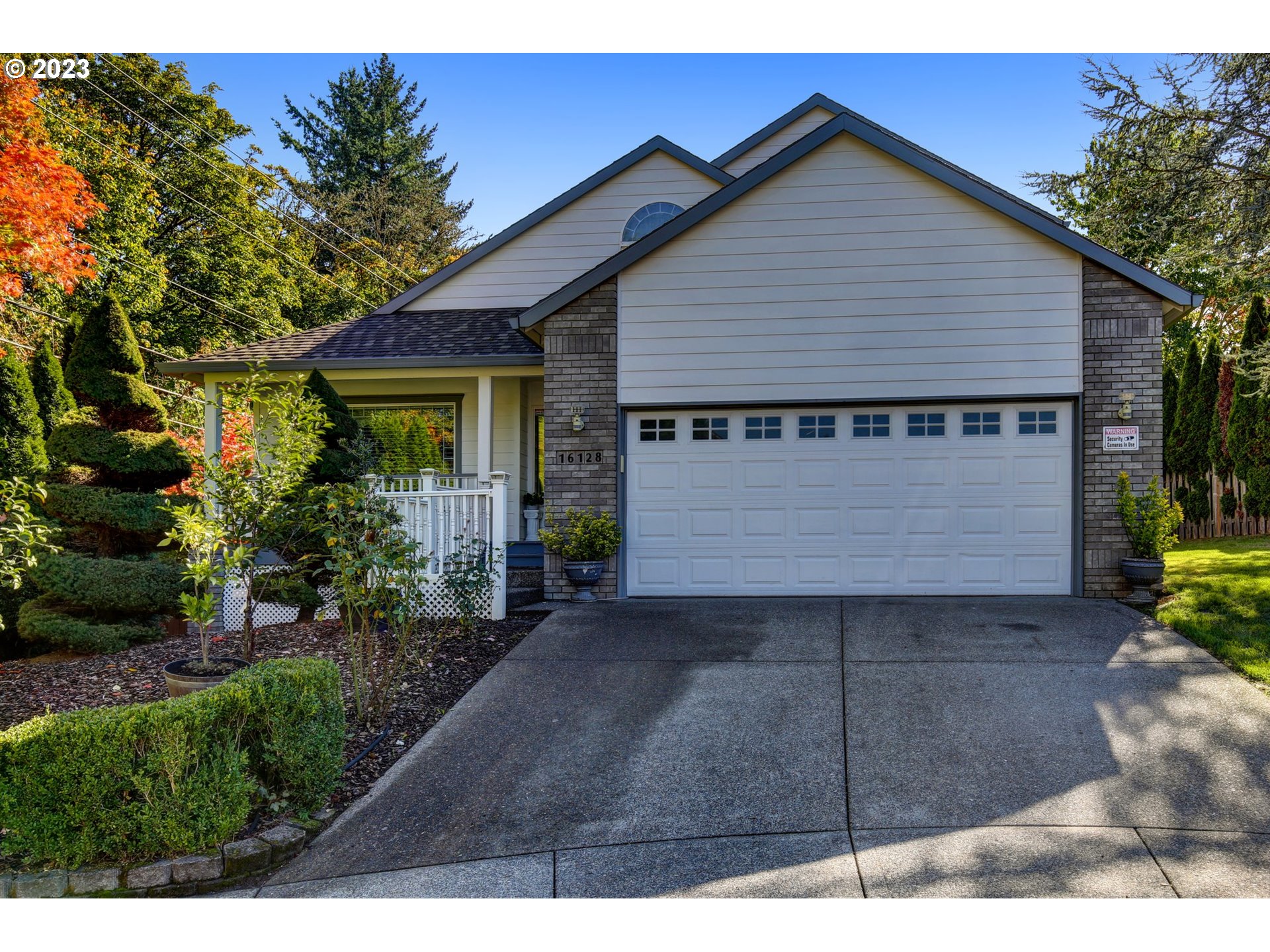 a view of a house with a yard and potted plants