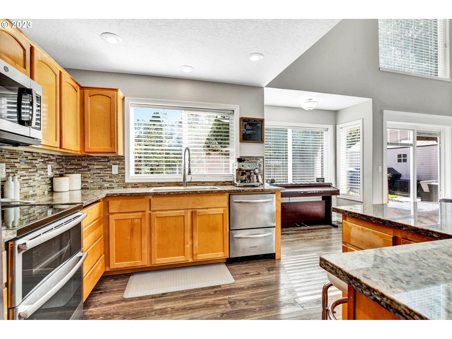 16128 Southeast Rural Court Portland, OR 97236 - Photo 11 of 37 a kitchen with stainless steel appliances granite countertop a stove a sink and a microwave