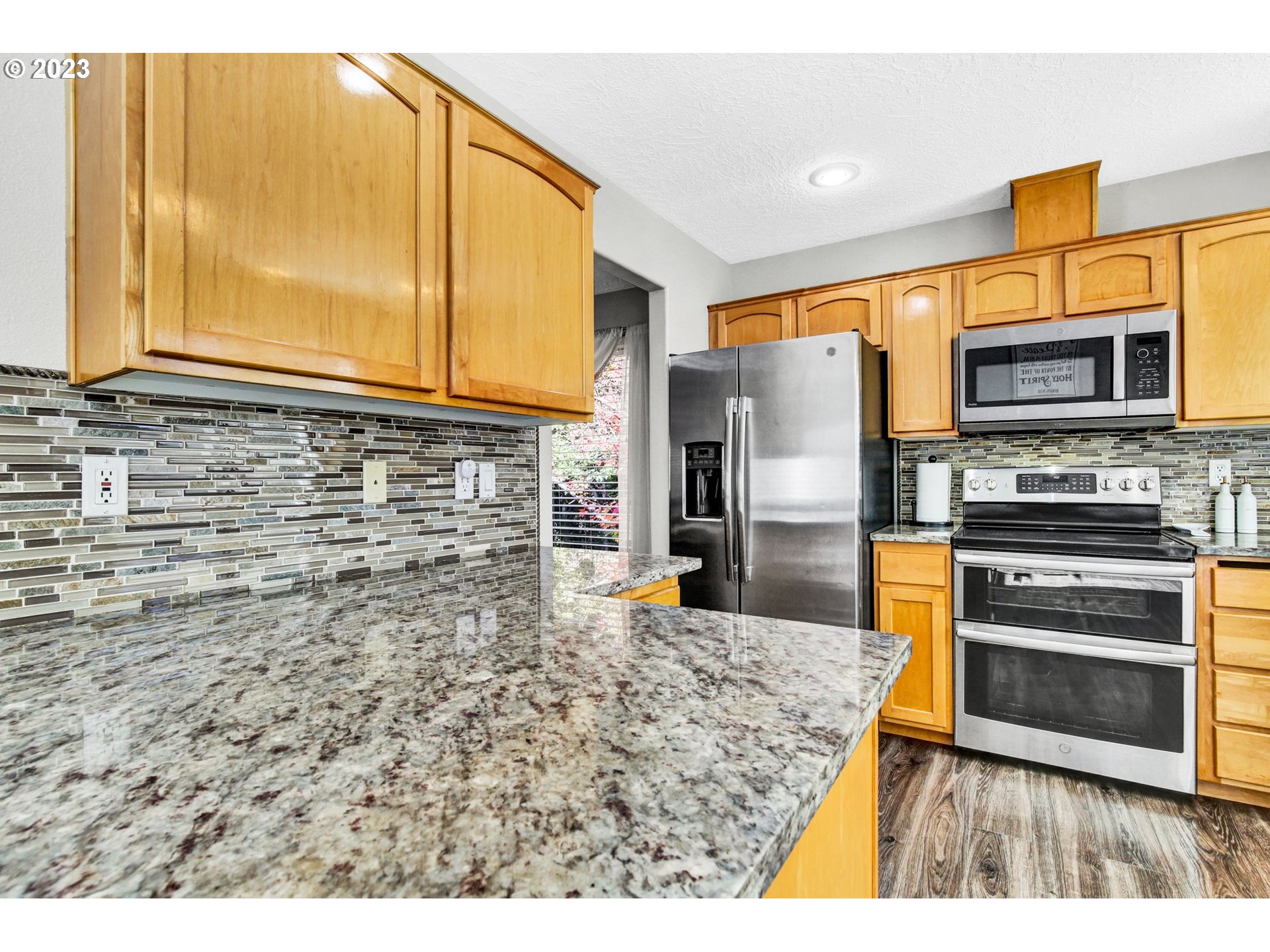 16128 Southeast Rural Court Portland, OR 97236 - Photo 13 of 37 a kitchen with stainless steel appliances kitchen island granite countertop a stove top oven a sink and a refrigerator