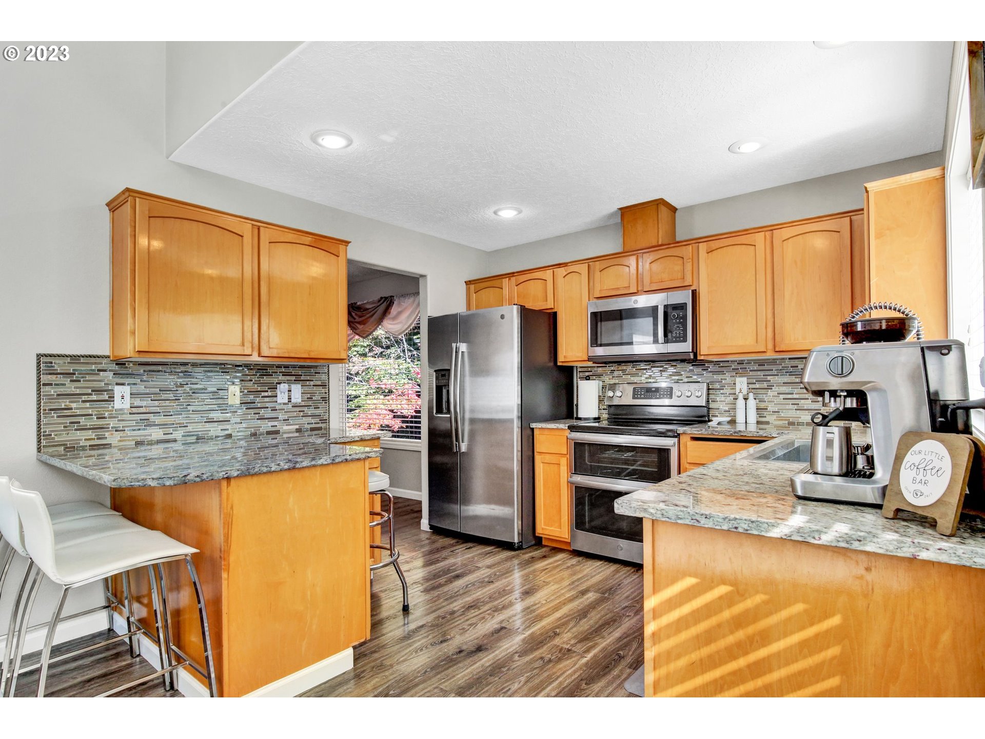 16128 Southeast Rural Court Portland, OR 97236 - Photo 10 of 37 a kitchen with stainless steel appliances granite countertop a refrigerator a stove top oven and a sink with large window
