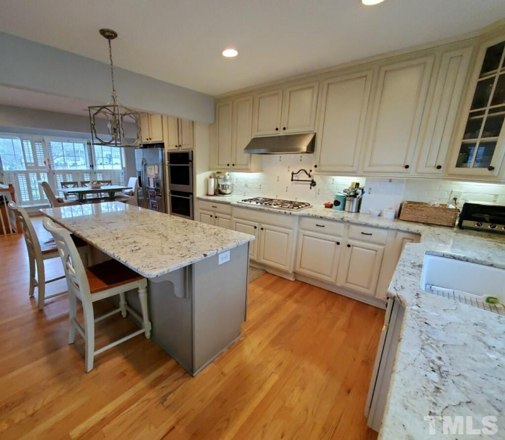 800 Lake Boone Trail Raleigh, NC 27607 - Photo 2 of 4 a kitchen with kitchen island a wooden floor and white appliances