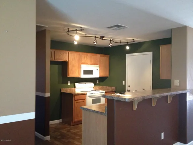 a room with kitchen island a sink a stove and a refrigerator