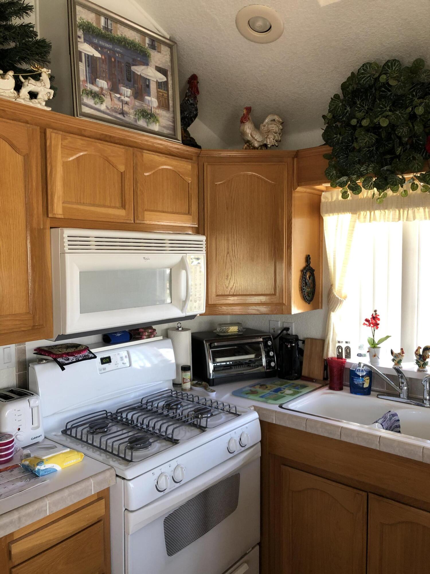 81620 Ave 49, Unit 160B Indio, CA 92201 - Photo 4 of 18 a kitchen with stainless steel appliances granite countertop a stove a sink and a microwave