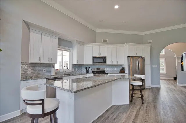 a kitchen with a sink cabinets and wooden floor