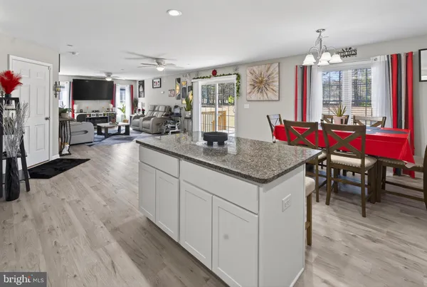 a view of kitchen island dining table wooden floor and living room