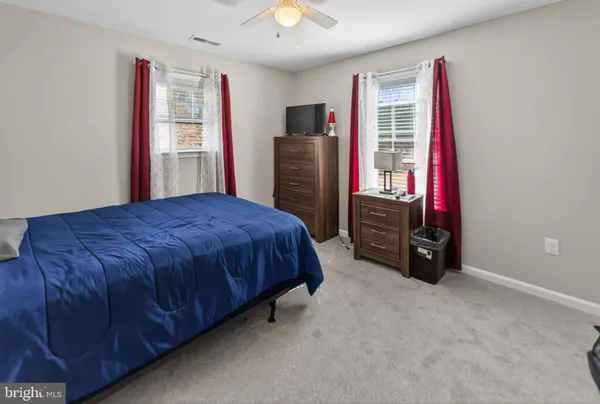 a bedroom with a bed closet and a flat tv screen