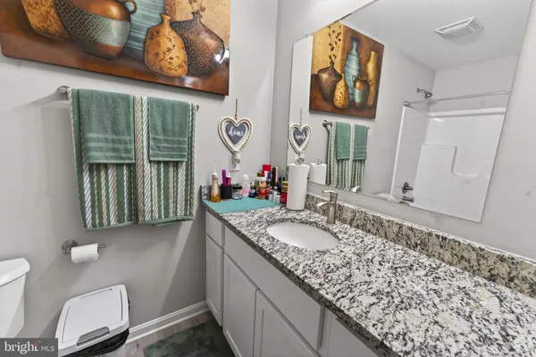 a bathroom with a granite countertop sink and a mirror