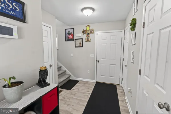 a view of a hallway to a livingroom with wooden floor and entryway