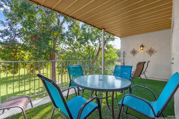 a balcony with table and chairs